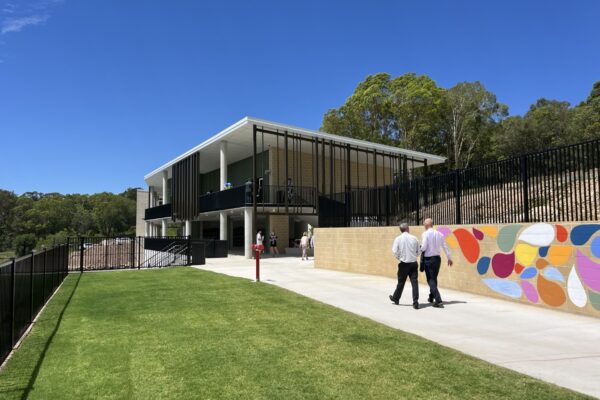 Exterior view of Coolum Beach Christian College campus with walkway, green lawn, and colorful mural.