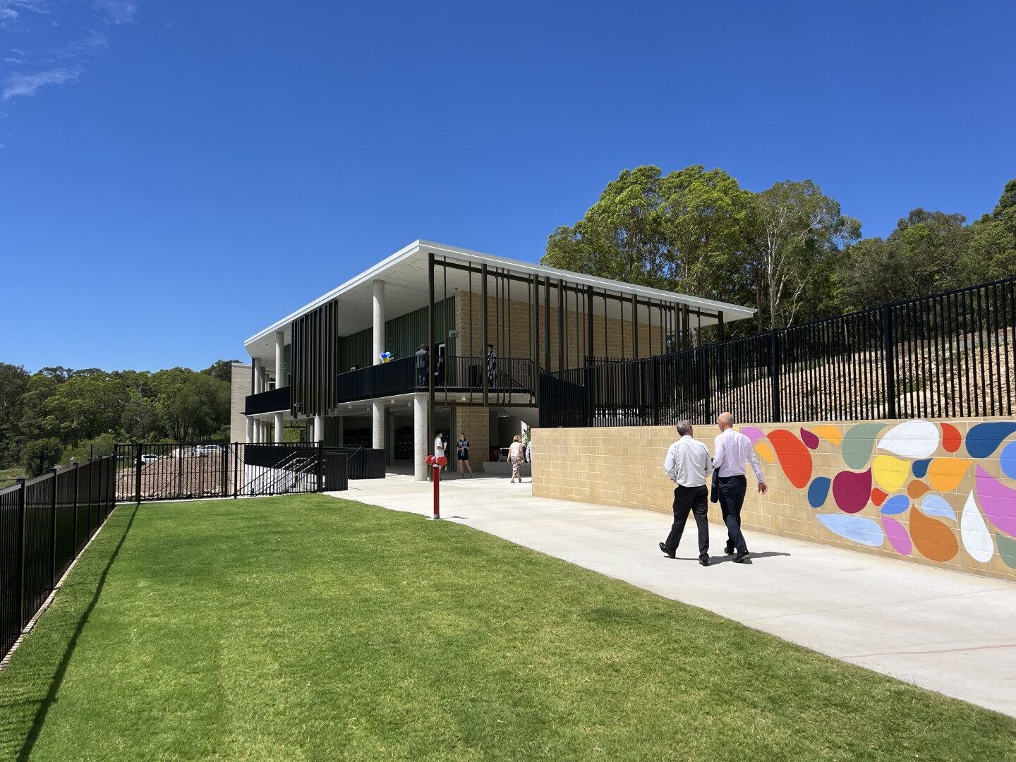 Exterior view of Coolum Beach Christian College campus with walkway, green lawn, and colorful mural.